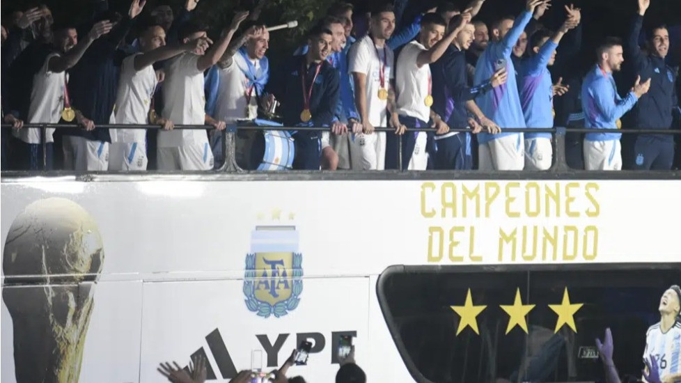 Pemain Argentina melambai dari bus yang membawa mereka ke Asosiasi Sepak Bola Argentina, tempat mereka akan bermalam setelah mendarat di bandara Ezeiza di Buenos Aires, Argentina (20/12/2022).