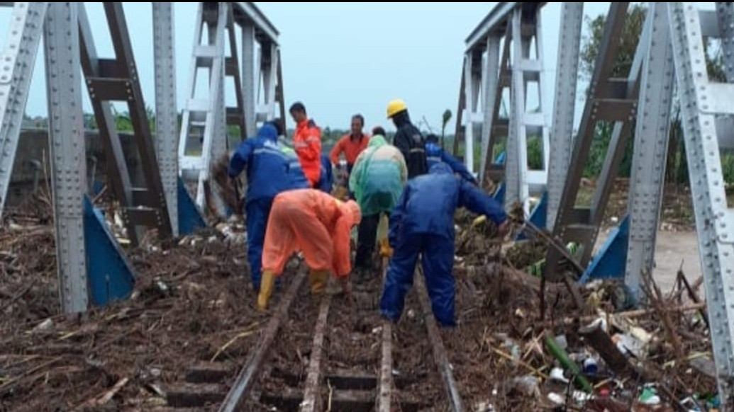 Petugas saat melakukan penanganan jalur kereta api yang terhambat akibat dampak dari genangan air, Sabtu (31/12/2022).
