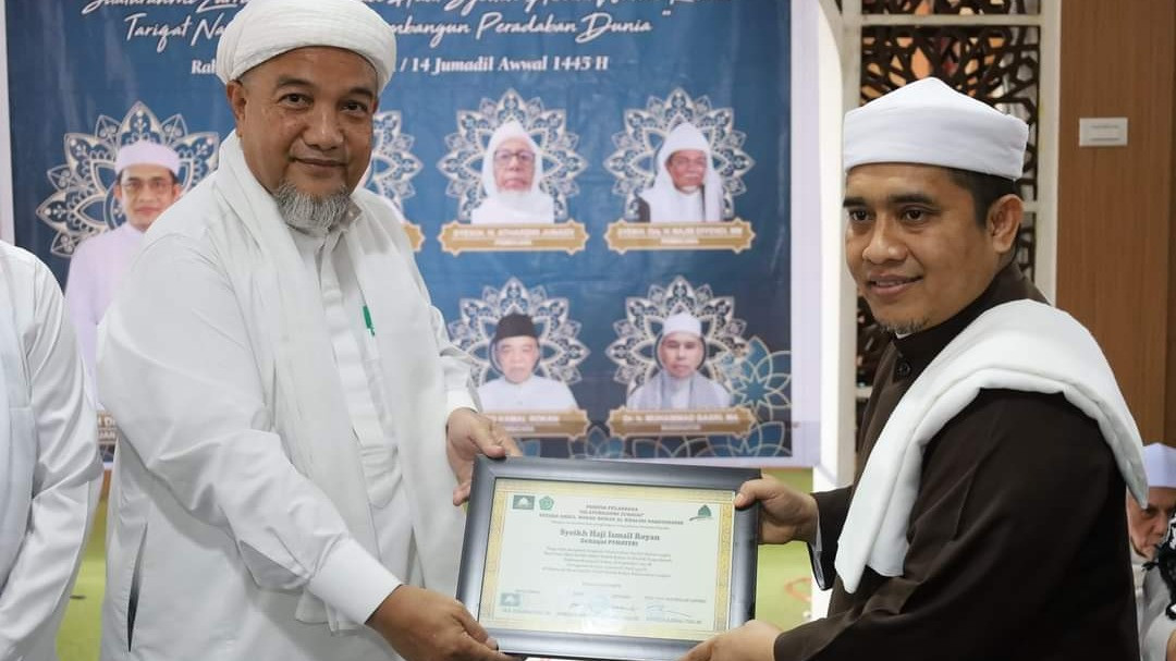 Tuan Guru Syekh DR Zikmal Fuad menyerahkan sertifikat seminar kepada Tuan Guru Syekh Ismail Royan usai seminar dan silaturahim zuriat Syekh Abdul Wahab Rokan di Besilam, Langkat, Selasa (28/11).