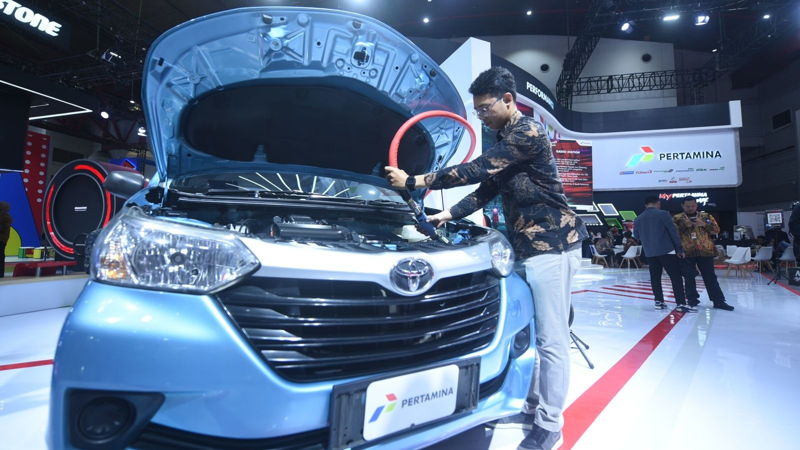 Fareza satria sakadanto electrical enginer Gagas energi Indonesia menunjukan cara pengisian BBG di salah satu kendaraan di Booth Pertamina IIMS 2024, pada Kamis (15/2).