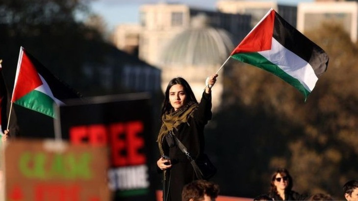   Arsip - Seorang wanita di tengah kerumunan massa mengibarkan bendera Palestina