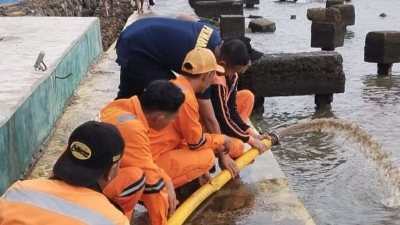 Petugas melakukan penanganan terhadap banjir rob yang merendam kawasan Tugu Arsa di Pulau Untung Jawa, Kepulauan Seribu, Jumat (2/1/2026).