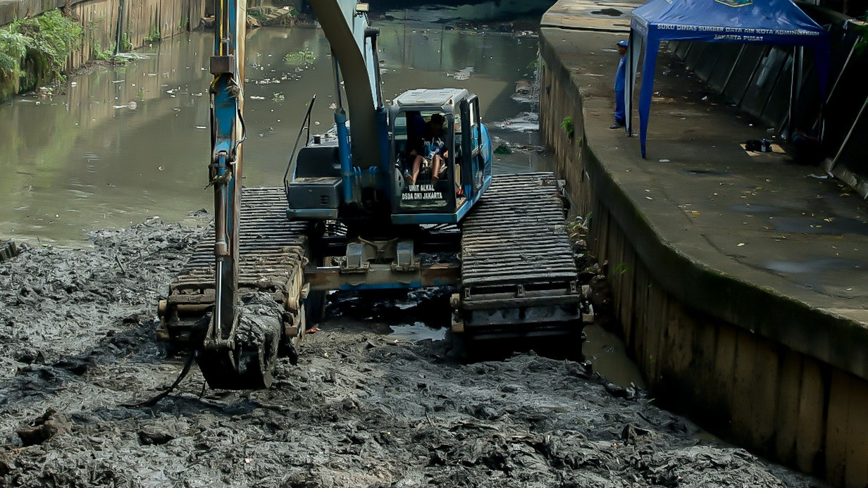 Petugas melakukan pengerukan lumpur di aliran Kali Ciliwung, kawasan Matraman, Jakarta Timur, menggunakan alat berat pada Jumat (22/5/2026).