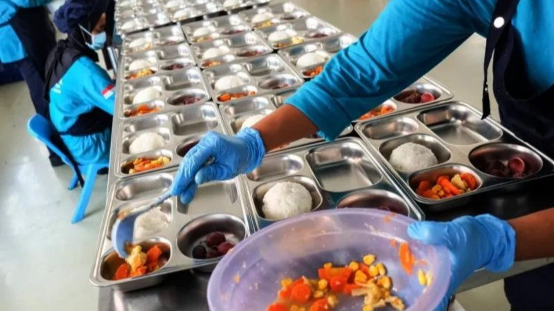 Ilustrasi - Pekerja menyiapkan paket makanan untuk program Makan Bergizi Gratis (MBG) di dapur Satuan Pelayanan Pemenuhan Gizi (SPPG) Jebres.