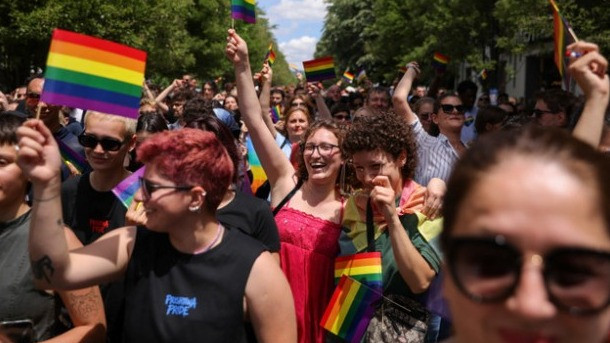 Ilustrasi partisipan membawa bendera berwarna pelangi mendukung LGBT