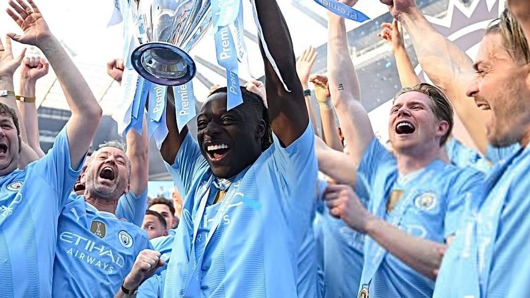 Jeremy Doku saat mengangkat trofi Premiere League bersama Manchester City