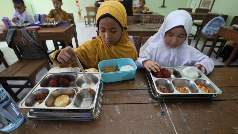 Sejumlah siswa menyantap menu Program Makan Bergizi Gratis (MBG) di SD Negeri 33 Banda Aceh, Banda Aceh, Aceh, Kamis (16/7).