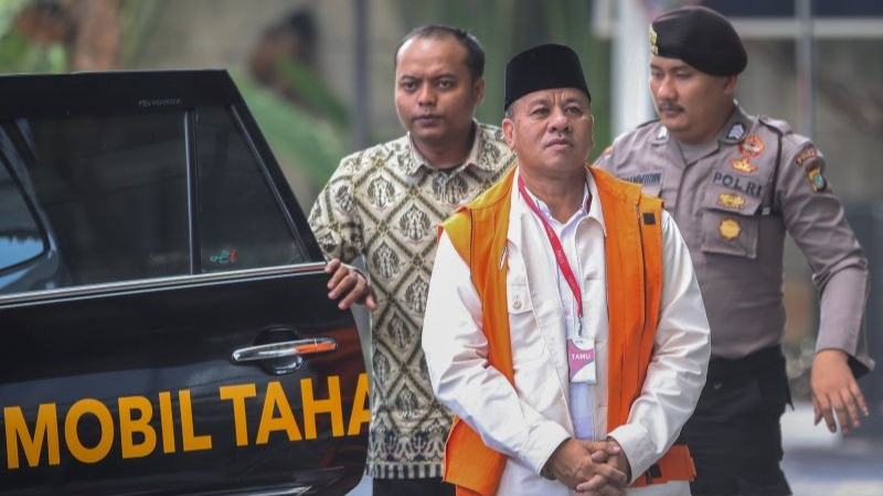 Tersangka kasus dugaan suap jual beli jabatan sekretaris daerah, Suhardiman Amby (tengah), berjalan menuju mobil tahanan usai menjalani pemeriksaan di Gedung Merah Putih KPK, Jakarta, Jumat (17/7/2026).