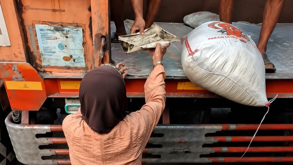 Potret seorang nenek menerima beras yang tercecer di dalam truk