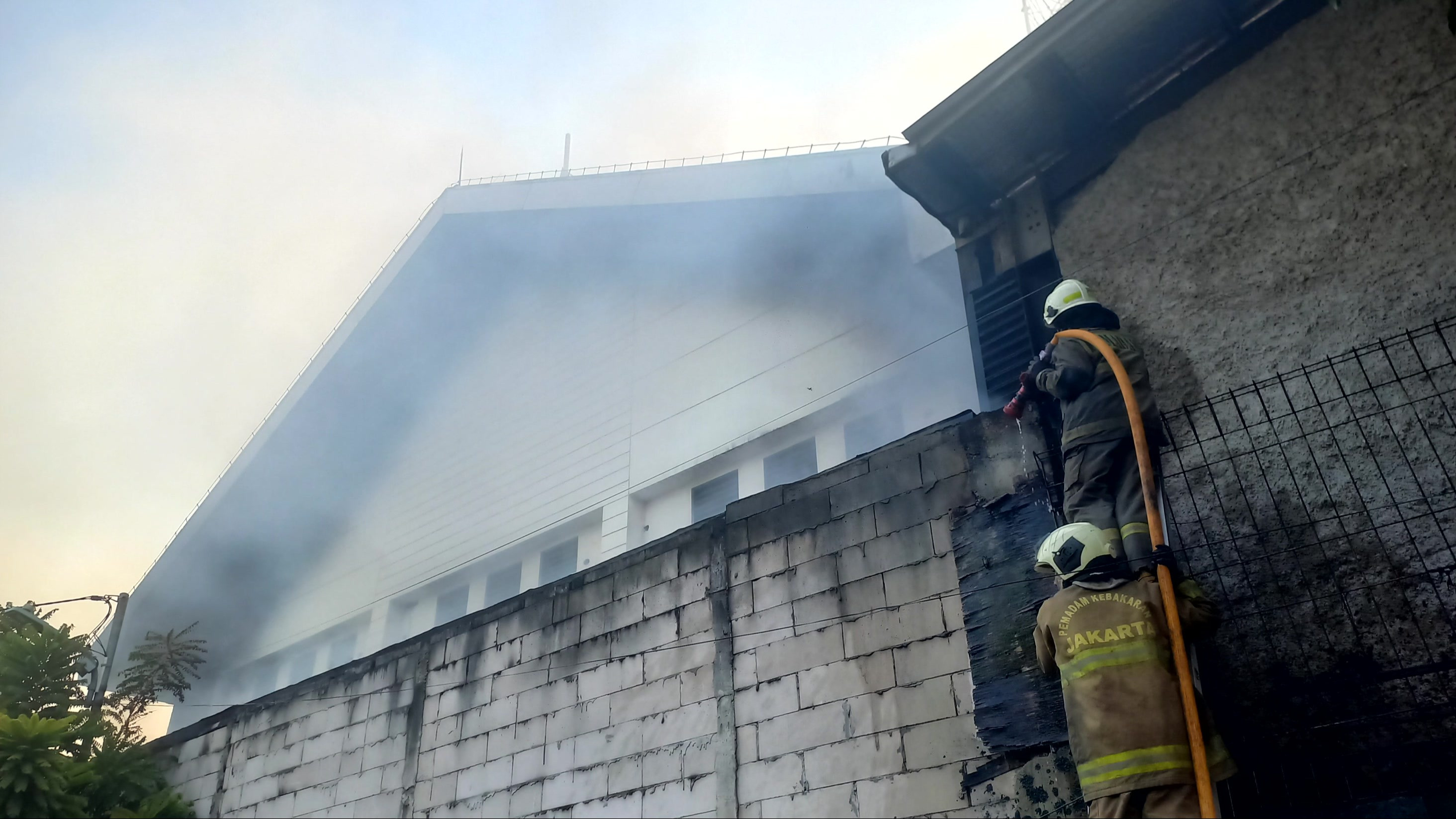 Petugas pemadam kebakaran berusaha memadamkan api yang diduga berasal dari gudang properti stasiun televisi di Kebon Jeruk, Jakarta Barat, Minggu (6/9/2026).