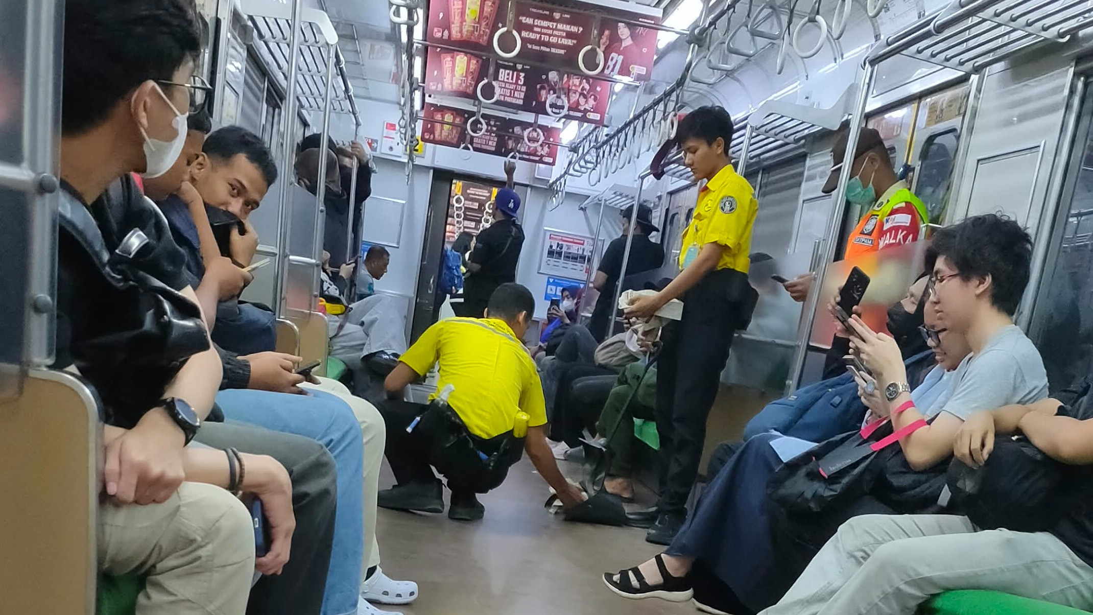 Petugas kebersihan mengambil kotoran diduga bekas pria yang BAB dalam gerbong KRL relasi Bogor-Jakarta Kota viral