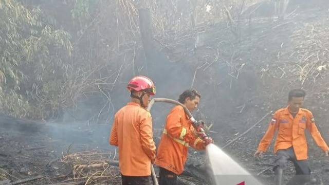 Petugas BPBD Kabupaten Muara Enim melakukan pemadaman kebakaran hutan dan lahan (karhutla) serta kebakaran rumah warga di Desa Karang Raja, Kabupaten Muara Enim, Sumatera Selatan, Senin (12/10).